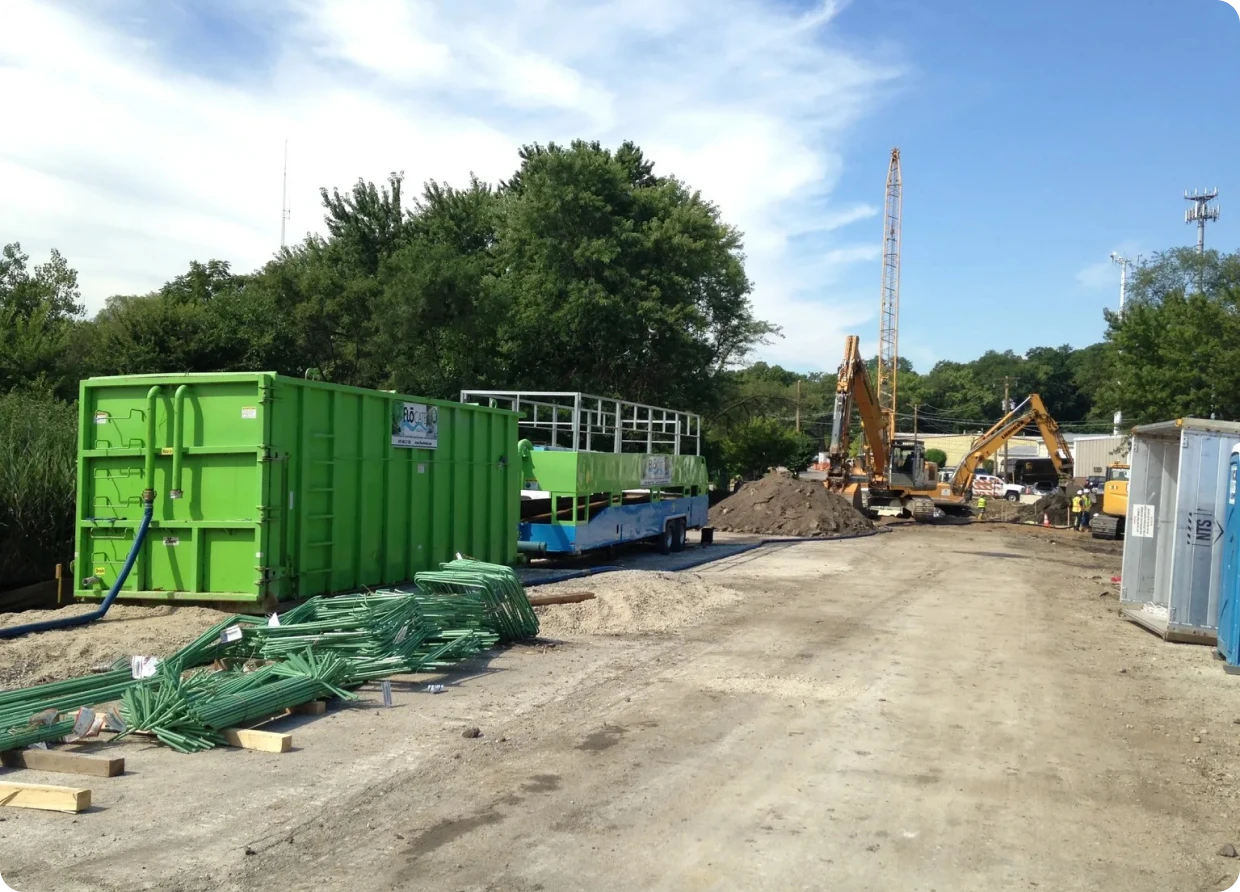 Green container near construction equipment