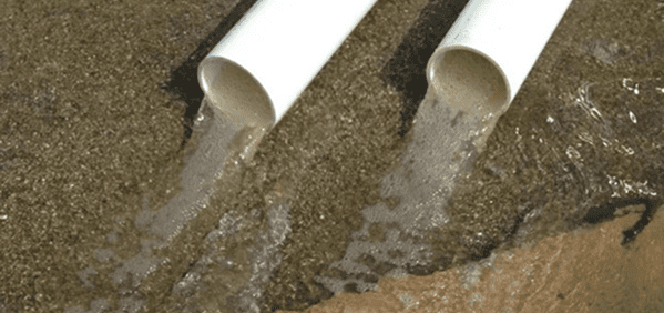 Water flowing from two white pipes