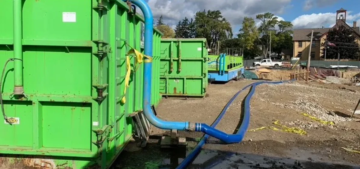 Construction area with green waste containers.